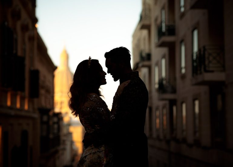 A man and woman standing in a city, captured beautifully by a Palazzo Parisio Malta Wedding Photographer.